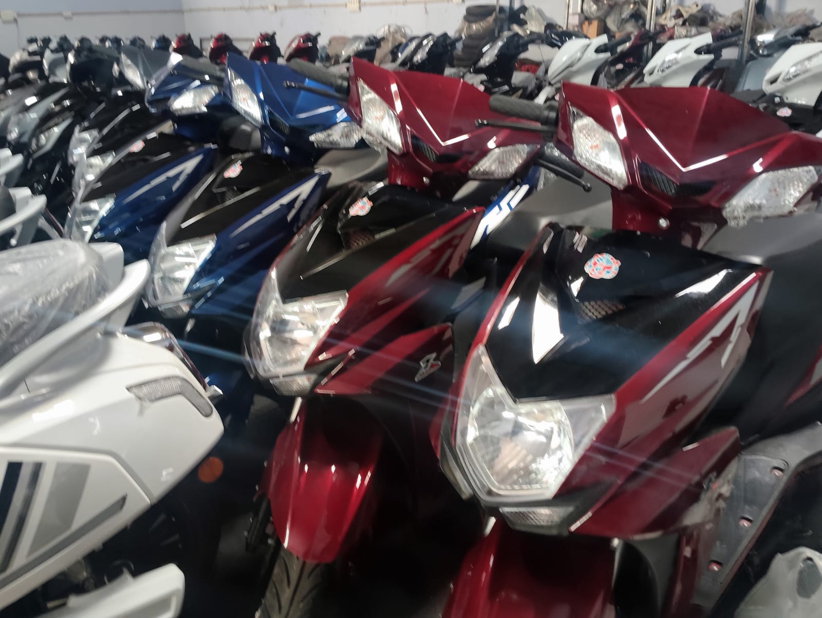 Rows of new electric scooters in stock at an Ad Value Global EV distribution warehouse